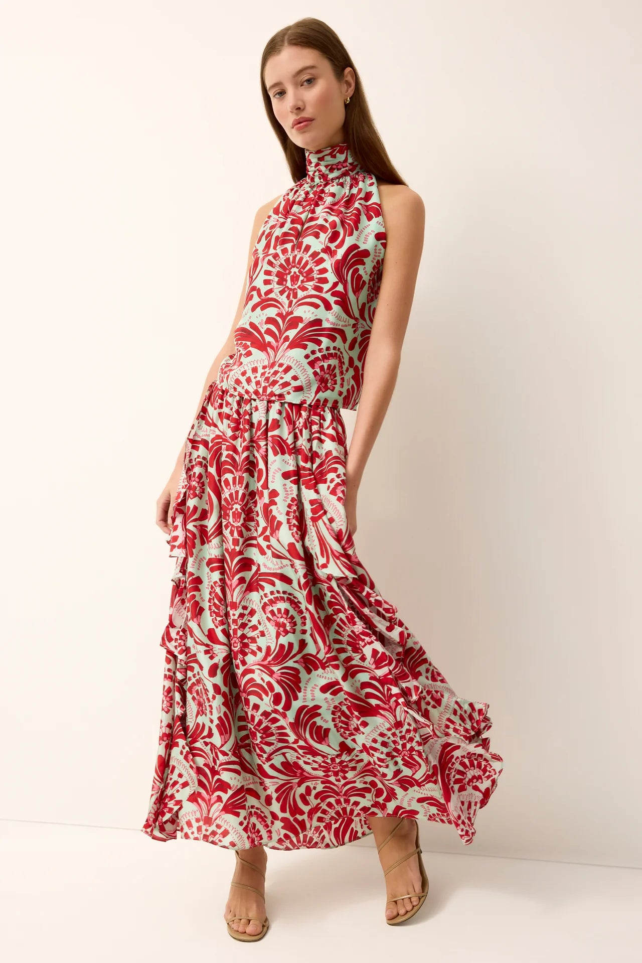 Woman wearing a red and white floral patterned dress on a white background