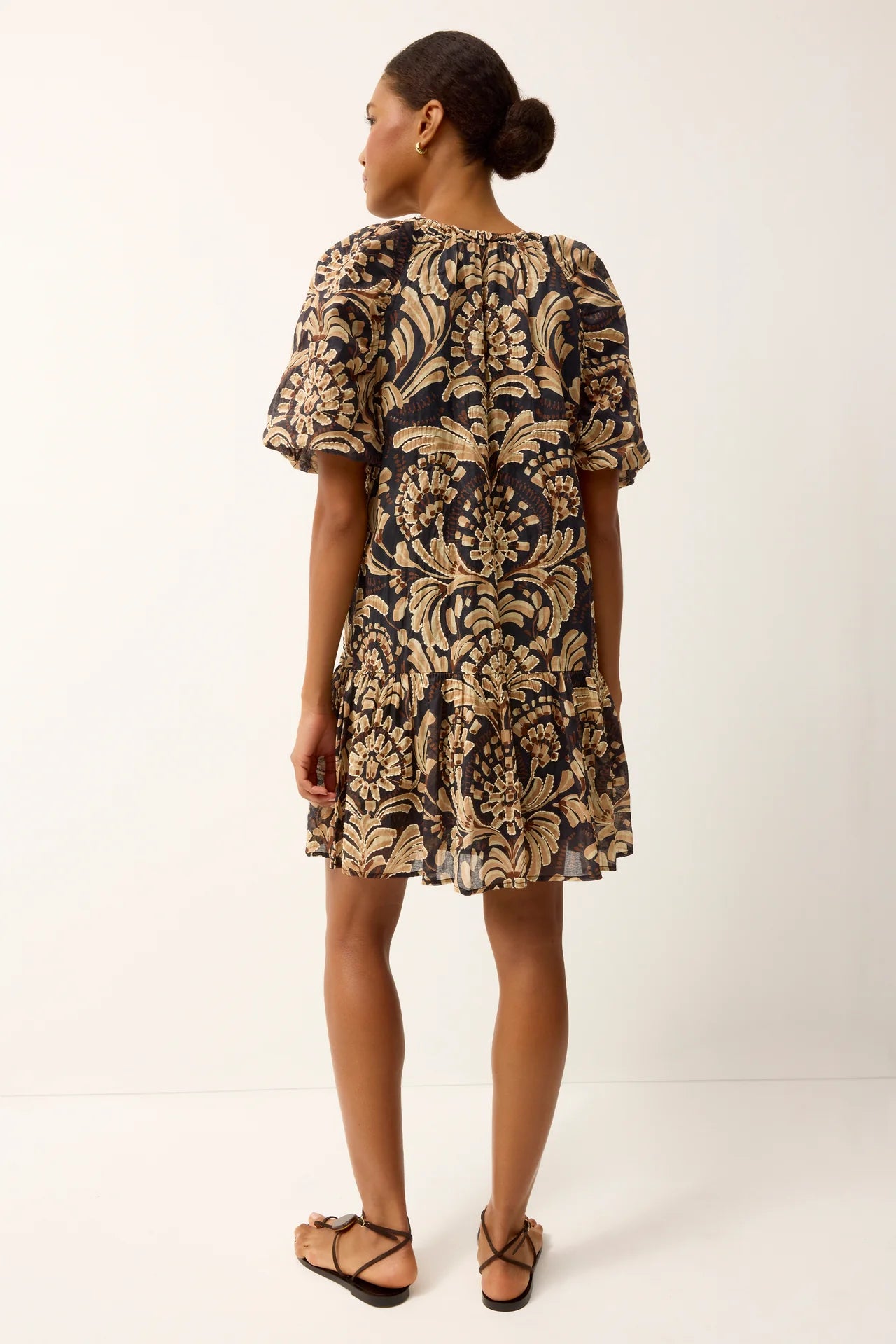 Woman wearing a patterned dress on a white background