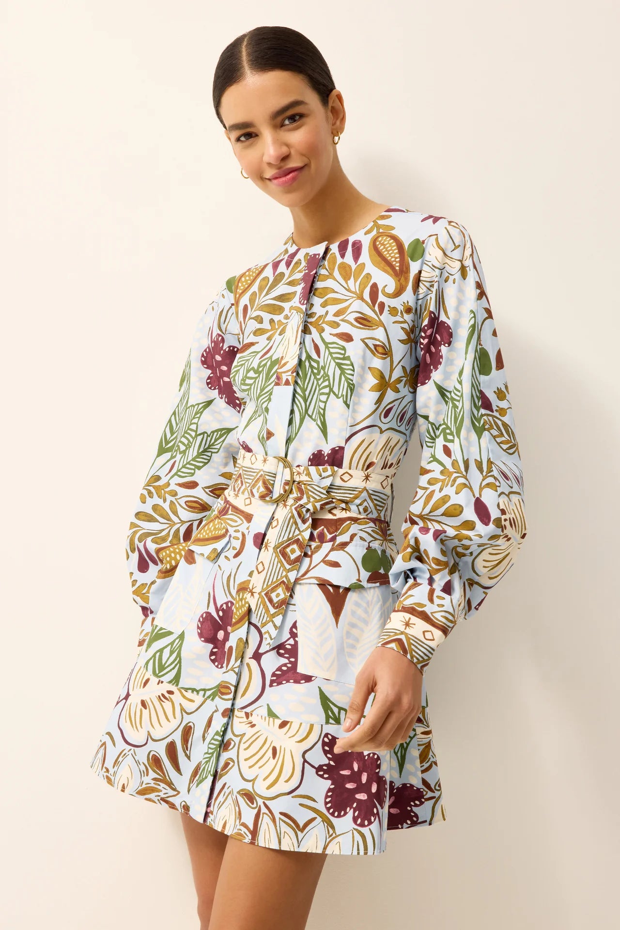 Woman wearing a floral dress against a plain background