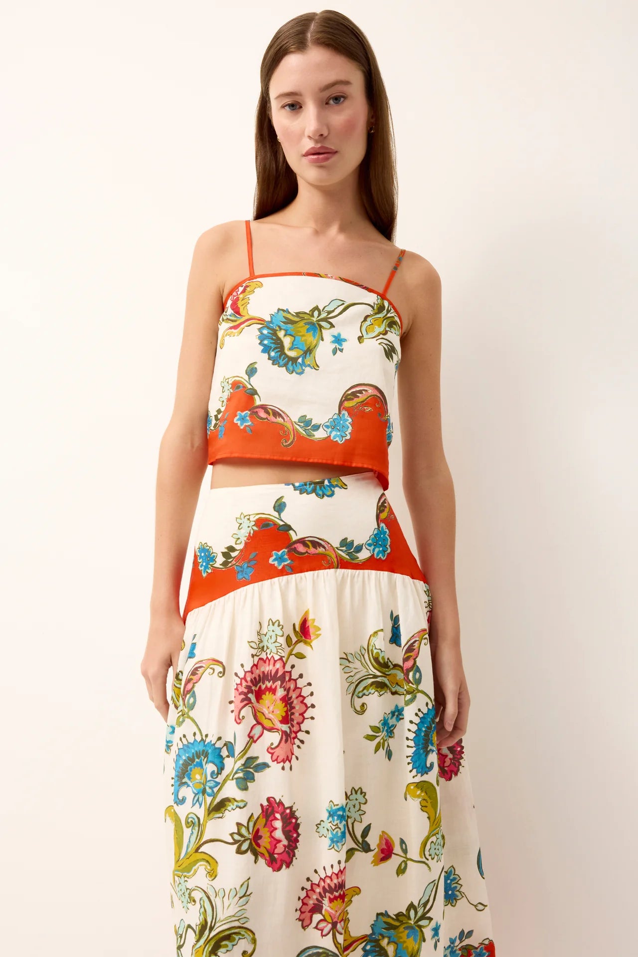 Woman wearing a colorful floral dress with a white background