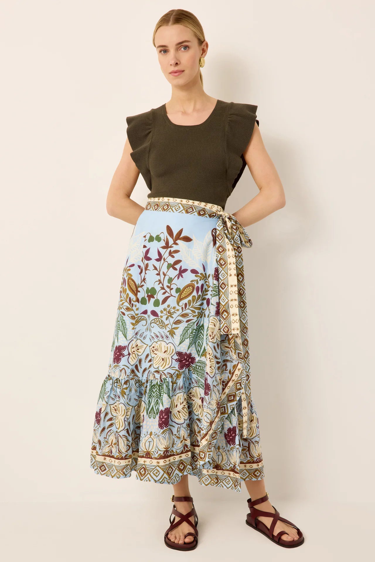 Woman wearing a floral skirt with a plain background