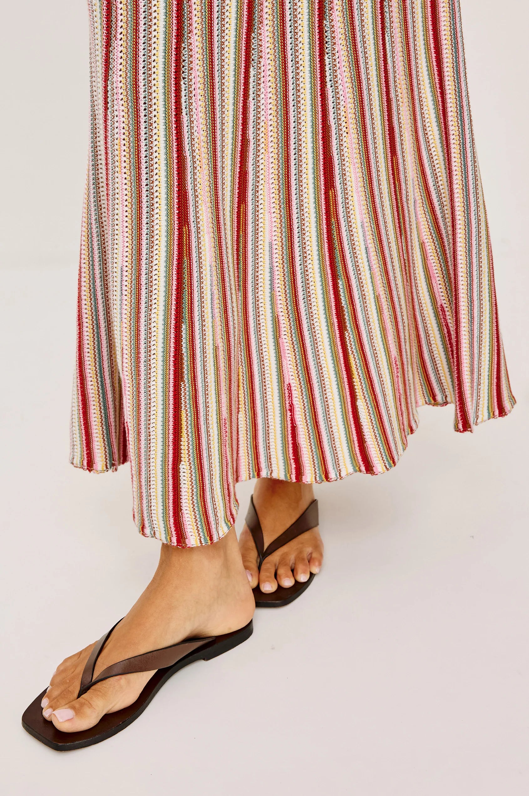 Multicolored striped skirt worn by a person on a white background