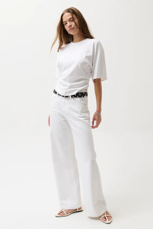 Woman wearing a white t-shirt and white pants on a white background