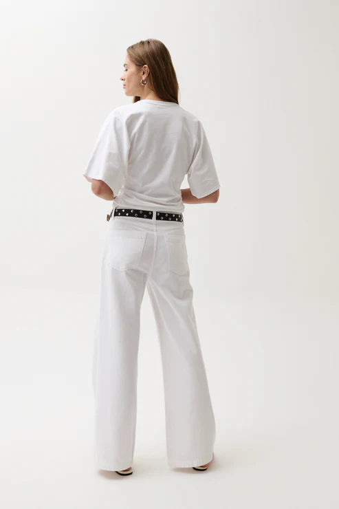 Person wearing a white outfit with a belt on a plain background