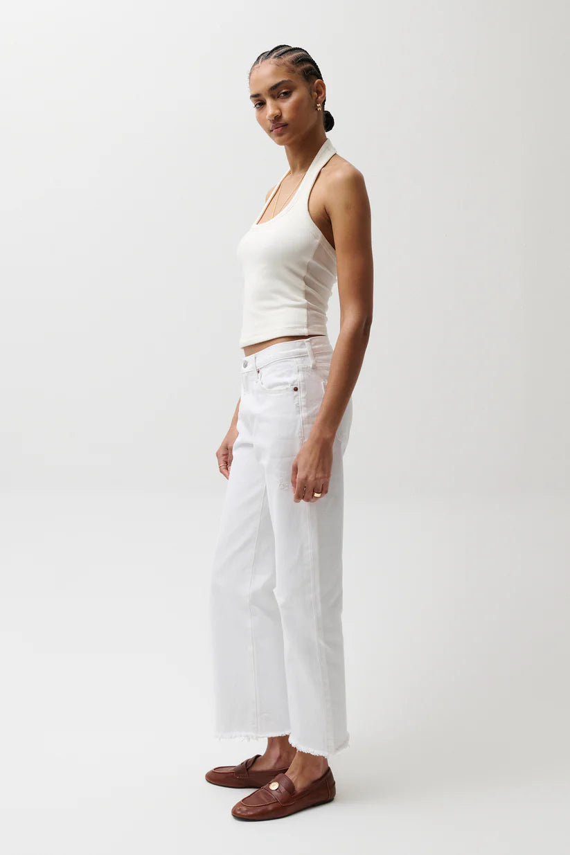 Woman wearing a white halter top and pants on a white background