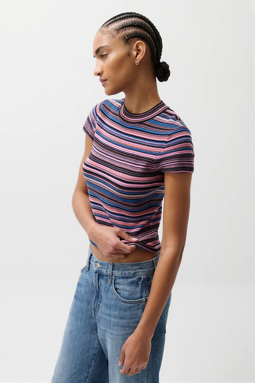 Person wearing a striped shirt and jeans on a plain background