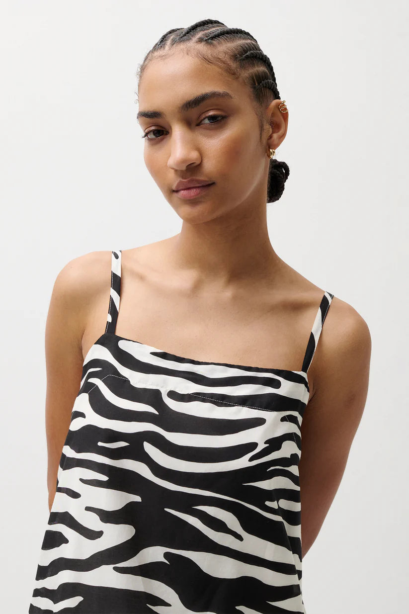 Woman wearing a zebra print dress against a white background
