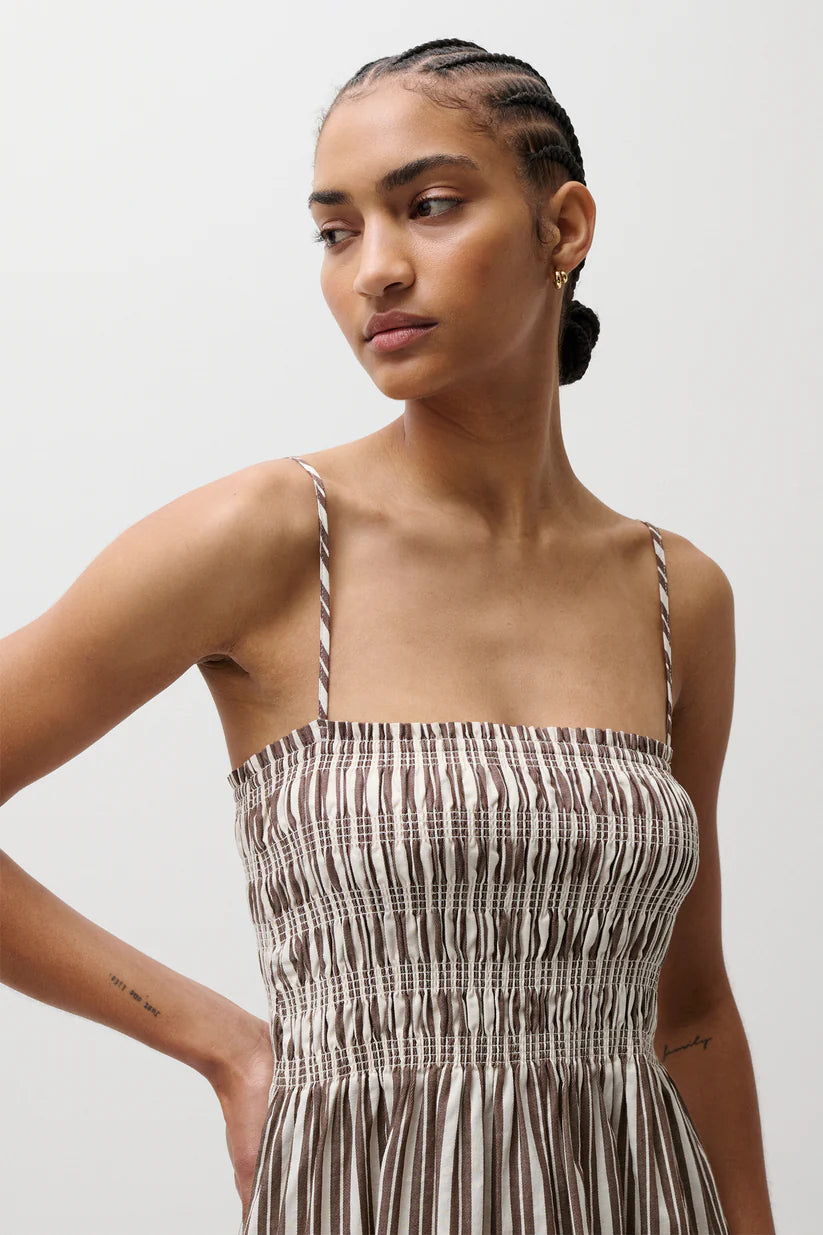 Woman wearing a patterned dress against a plain background