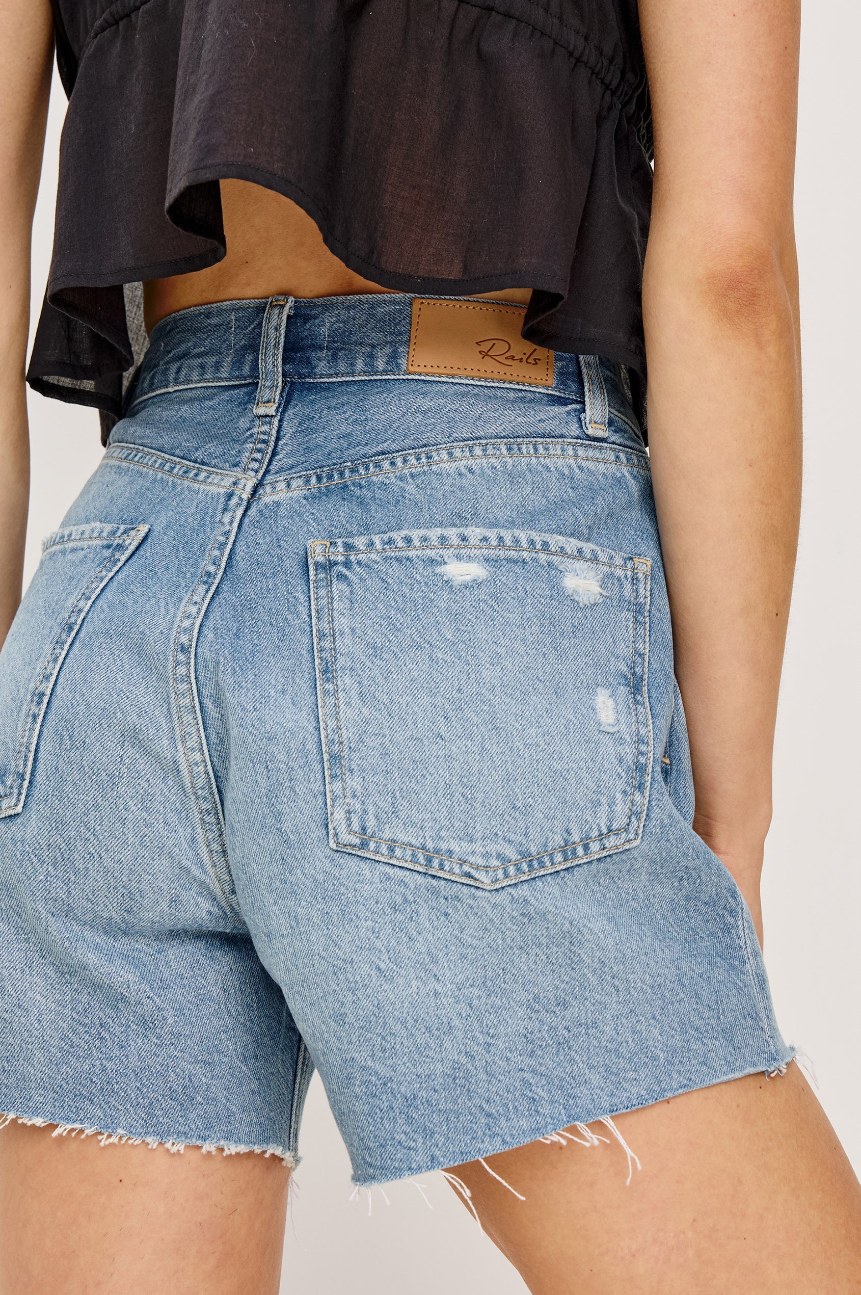 Denim shorts with a brand label on a plain background