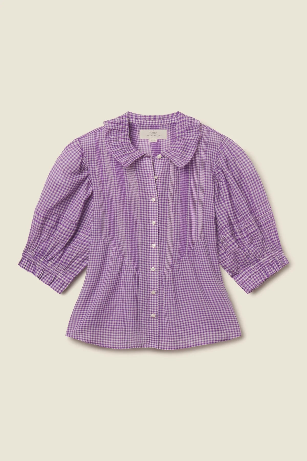 Purple checkered blouse on a beige background