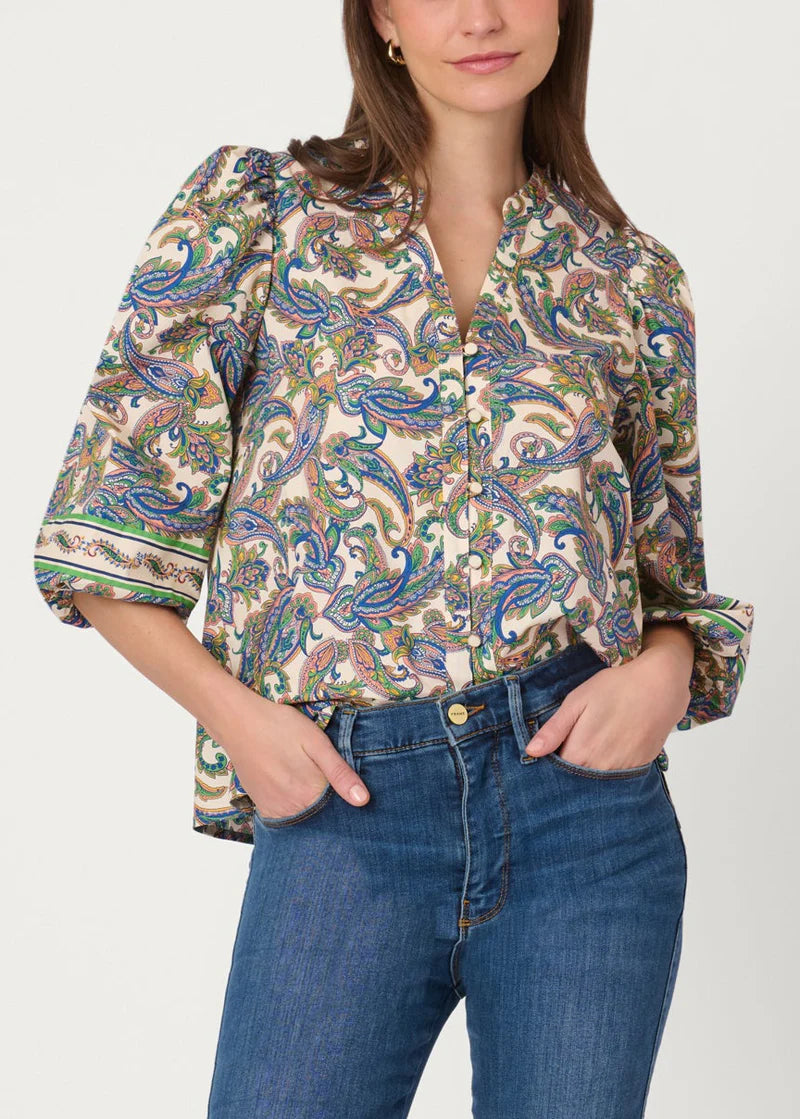 Woman wearing a patterned blouse and blue jeans on a white background
