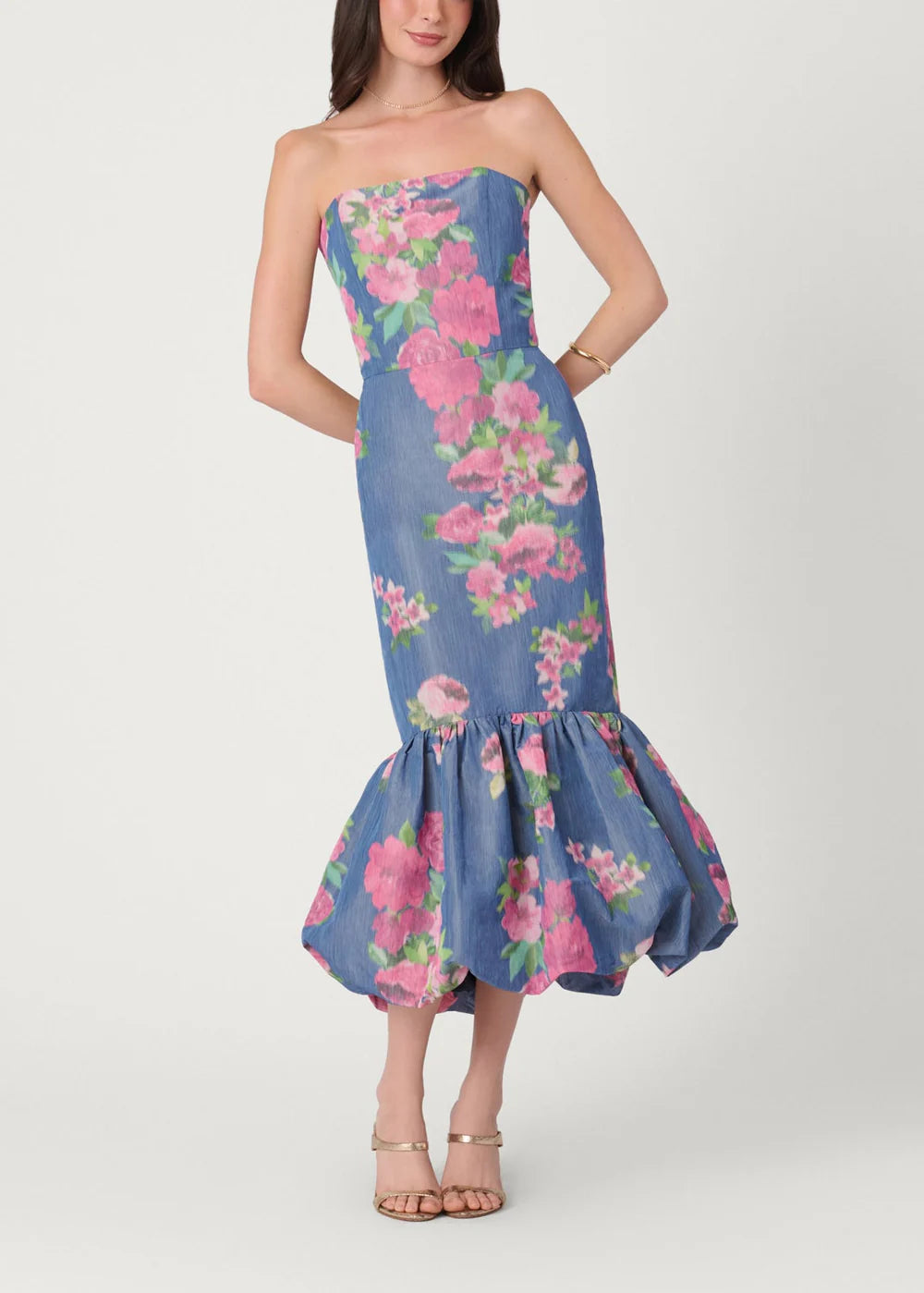 Woman wearing a strapless floral dress with a blue background