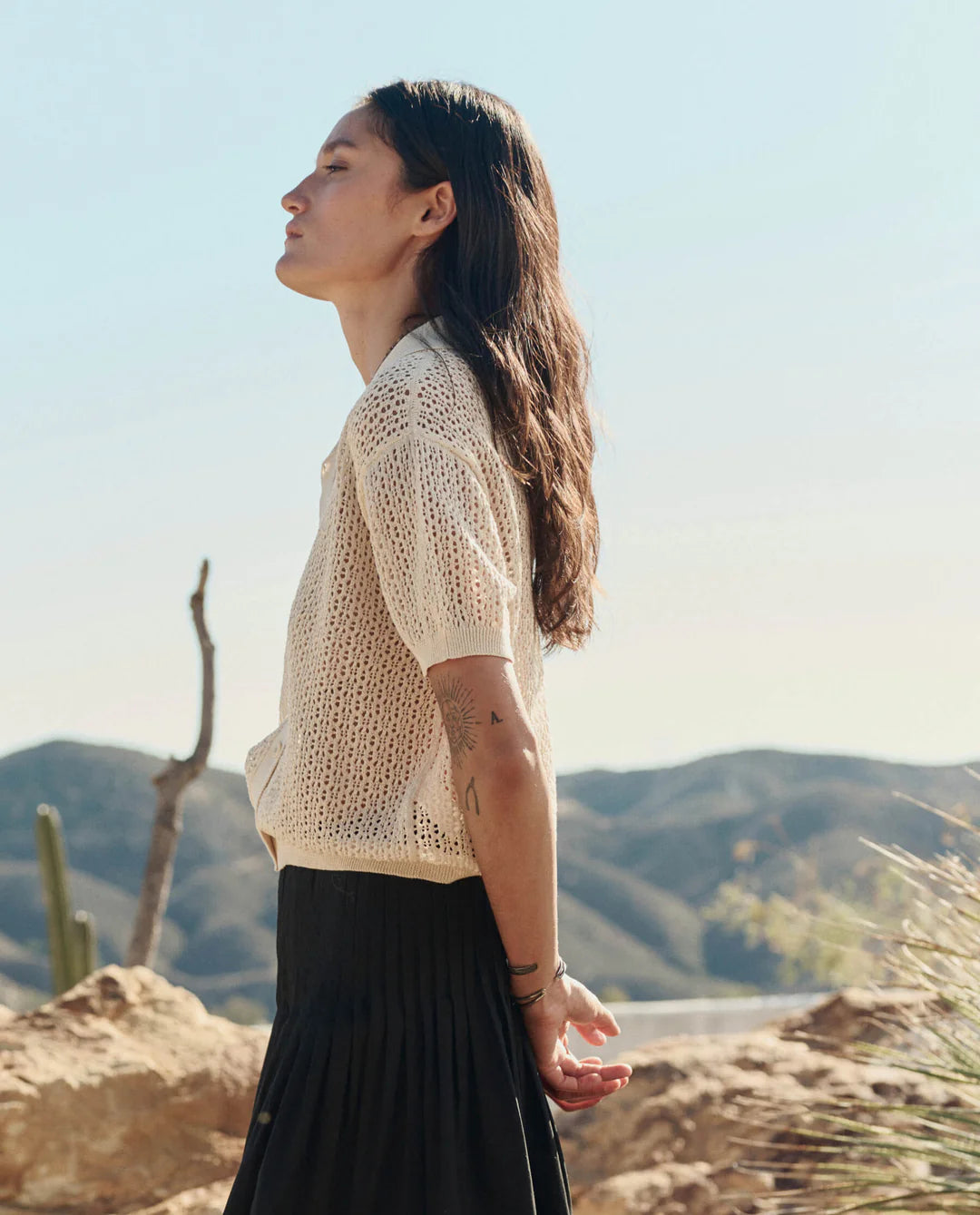 Woman standing outdoors with mountains in the background