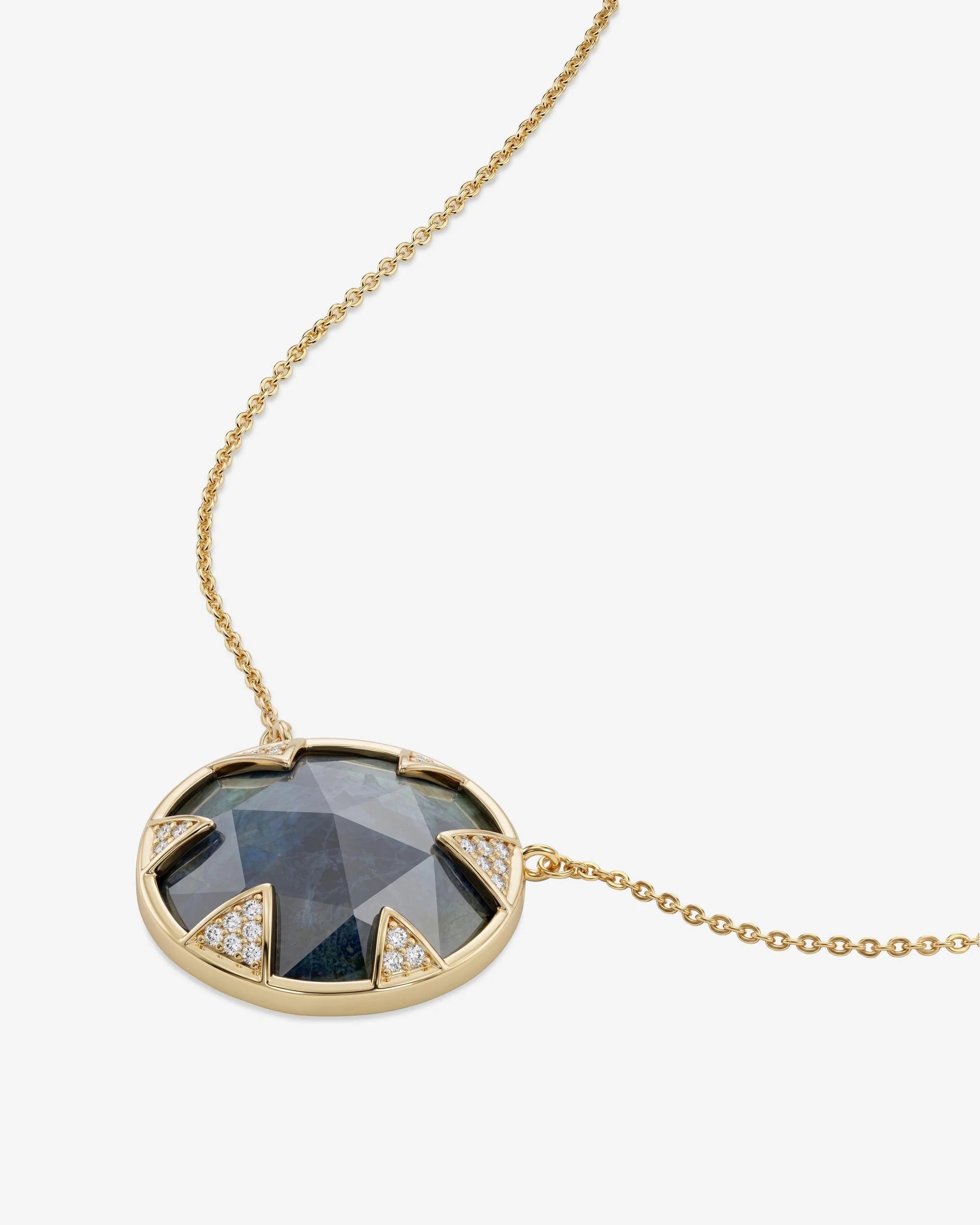 Gold necklace with a dark gemstone pendant on a white background