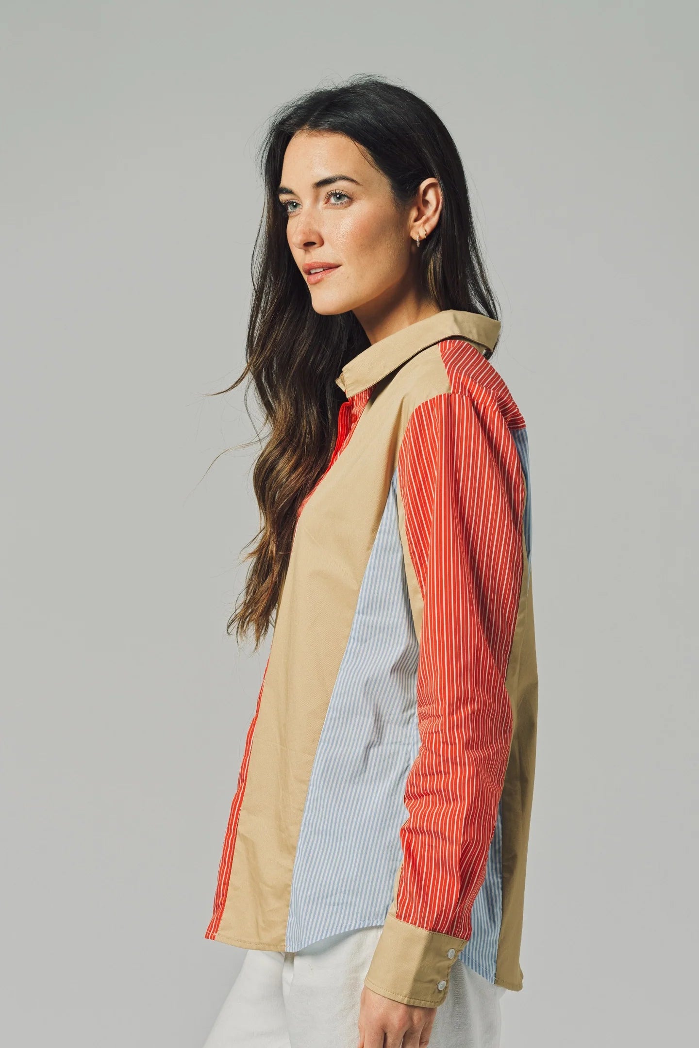Woman wearing a colorful, patterned shirt against a plain background