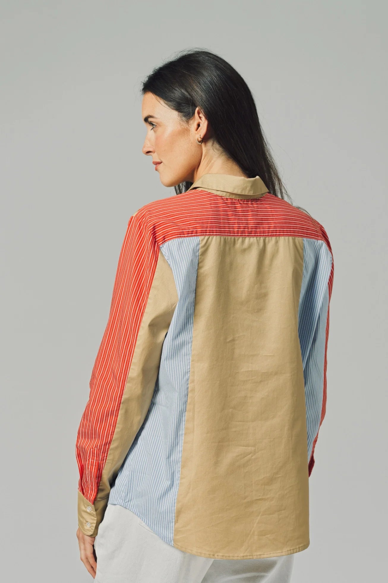 Woman wearing a colorful shirt with a neutral background
