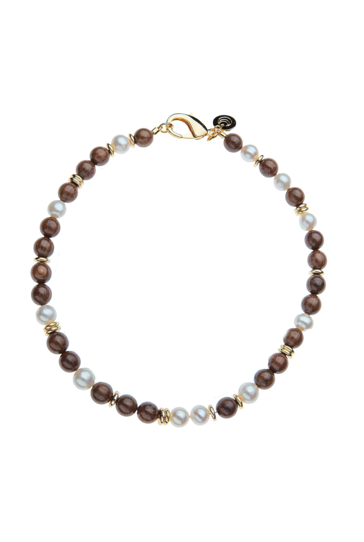 A beaded necklace featuring dark brown wooden beads, white faux pearls, and small gold spacer beads, completed with a gold clasp on a solid white background.