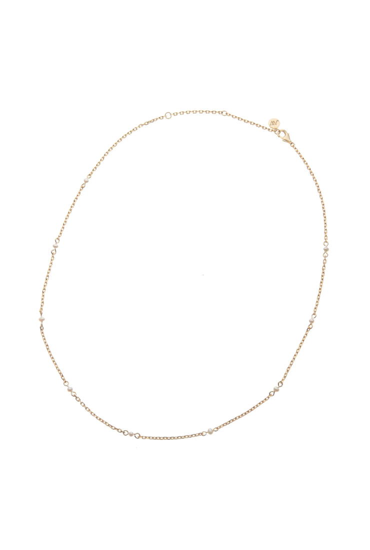 A delicate gold chain necklace with small, evenly spaced clear round beads, displayed in a circular shape against a plain white background.