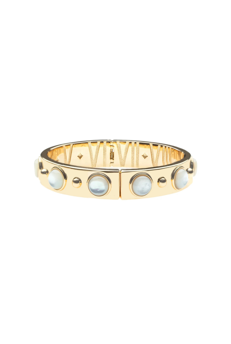 A gold bangle bracelet featuring inlaid oval mother-of-pearl stones and small gold dots, shown against a plain white background.