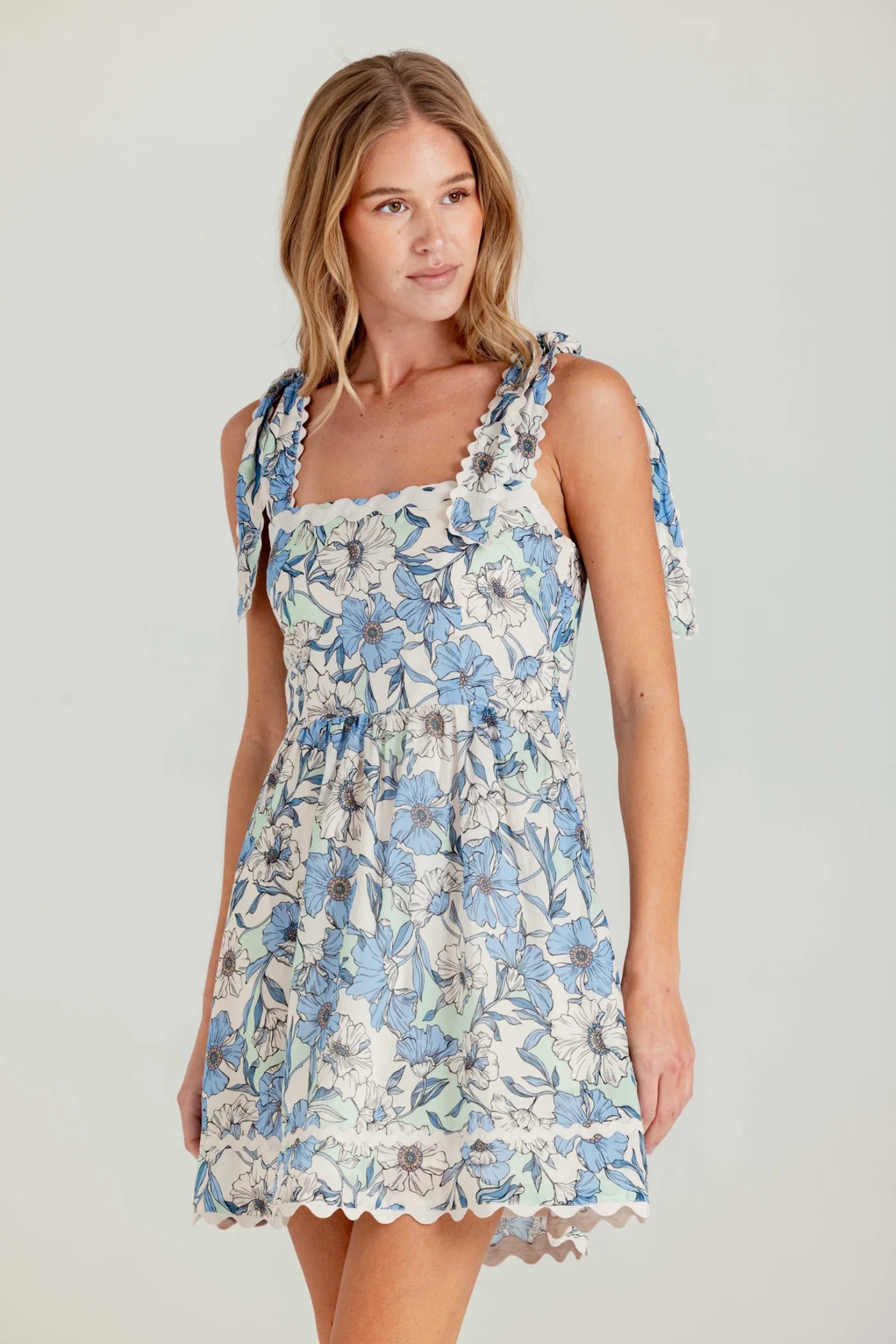 Woman wearing a floral dress on a plain background