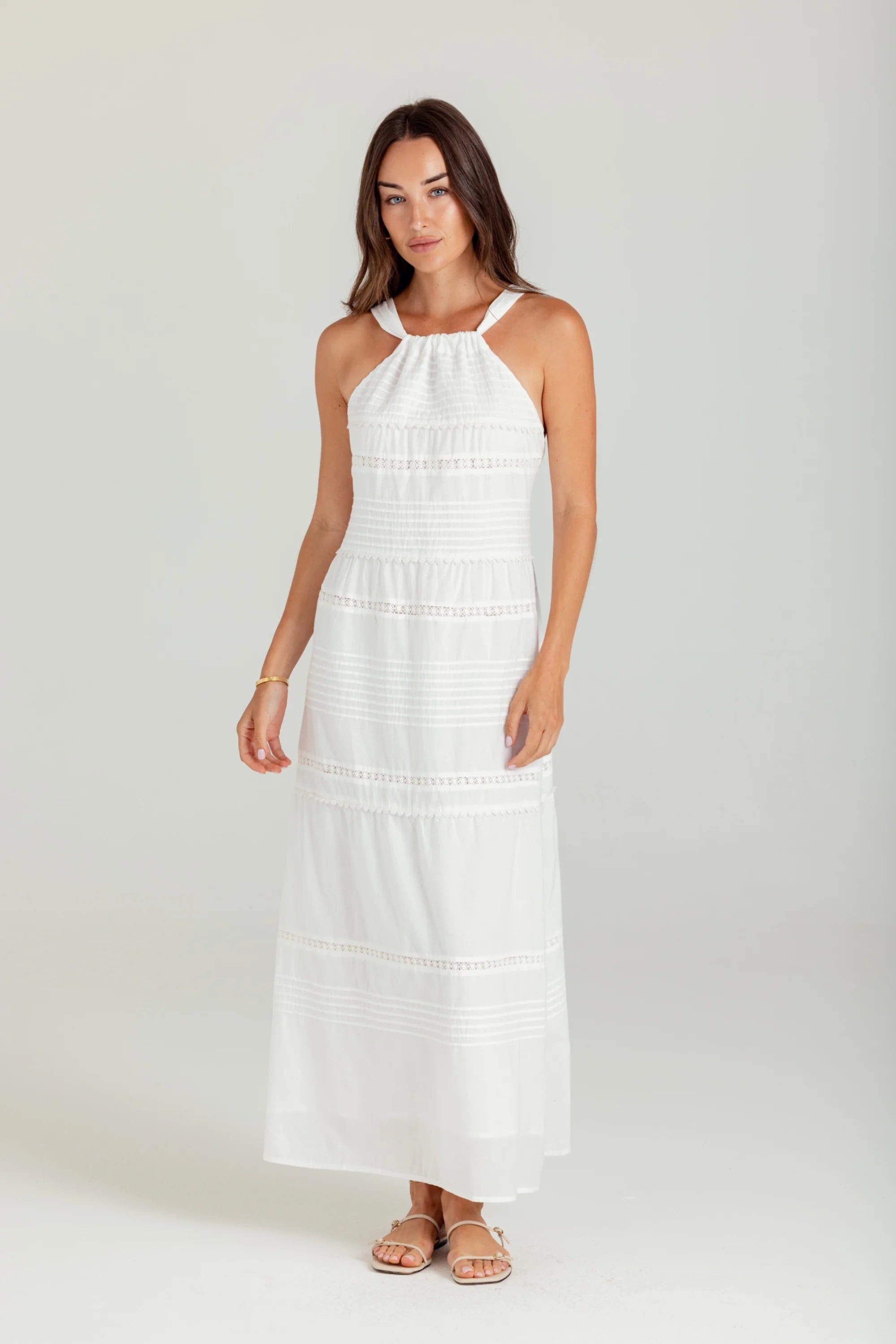 Woman wearing a white dress on a plain background