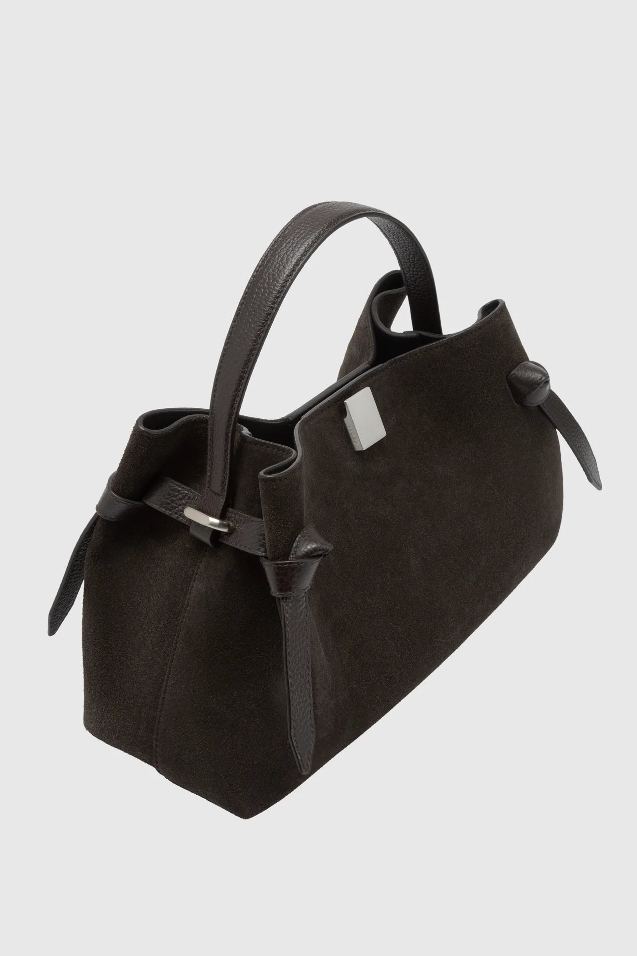 Black handbag with bow detail on a light gray background