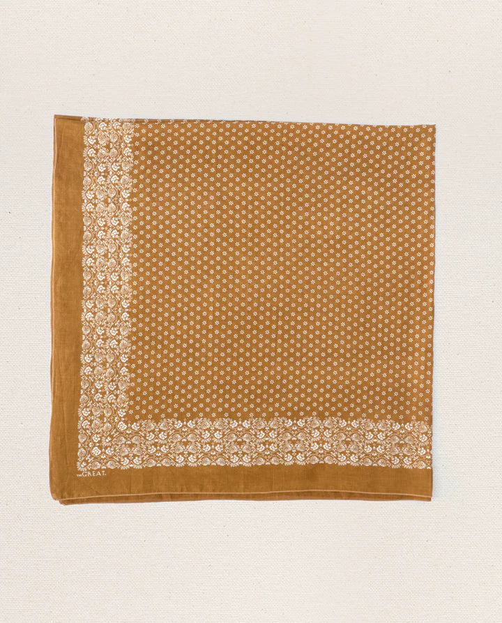Brown fabric square with white floral pattern on a light beige background