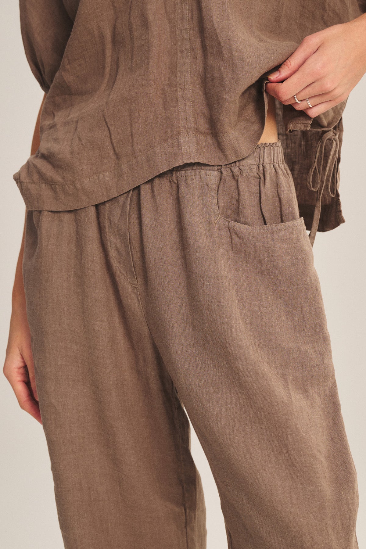 Brown pants worn by a person on a plain background