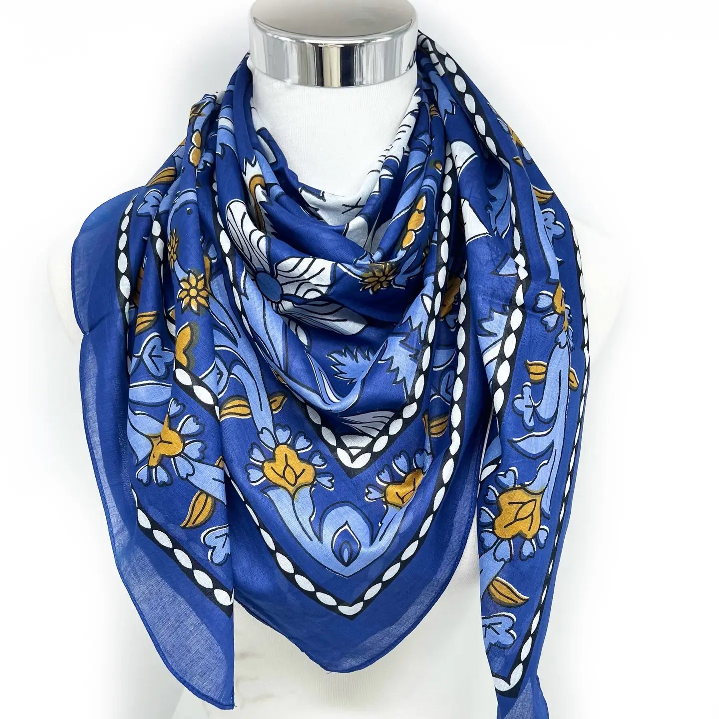 Blue patterned scarf on a mannequin with a white background