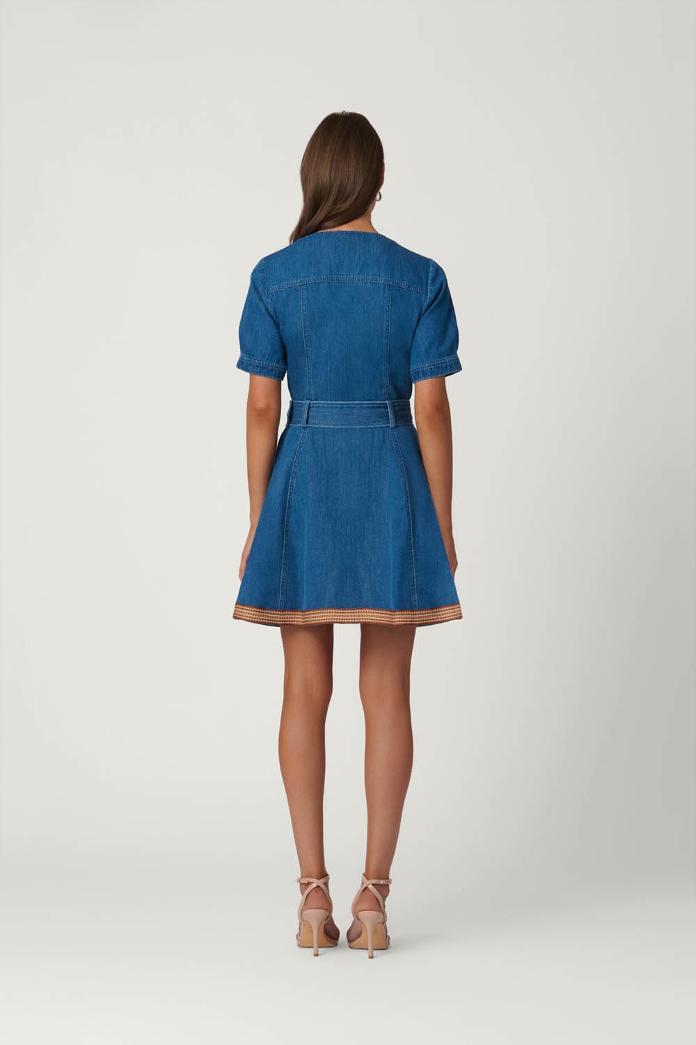 Woman wearing a blue denim dress on a white background