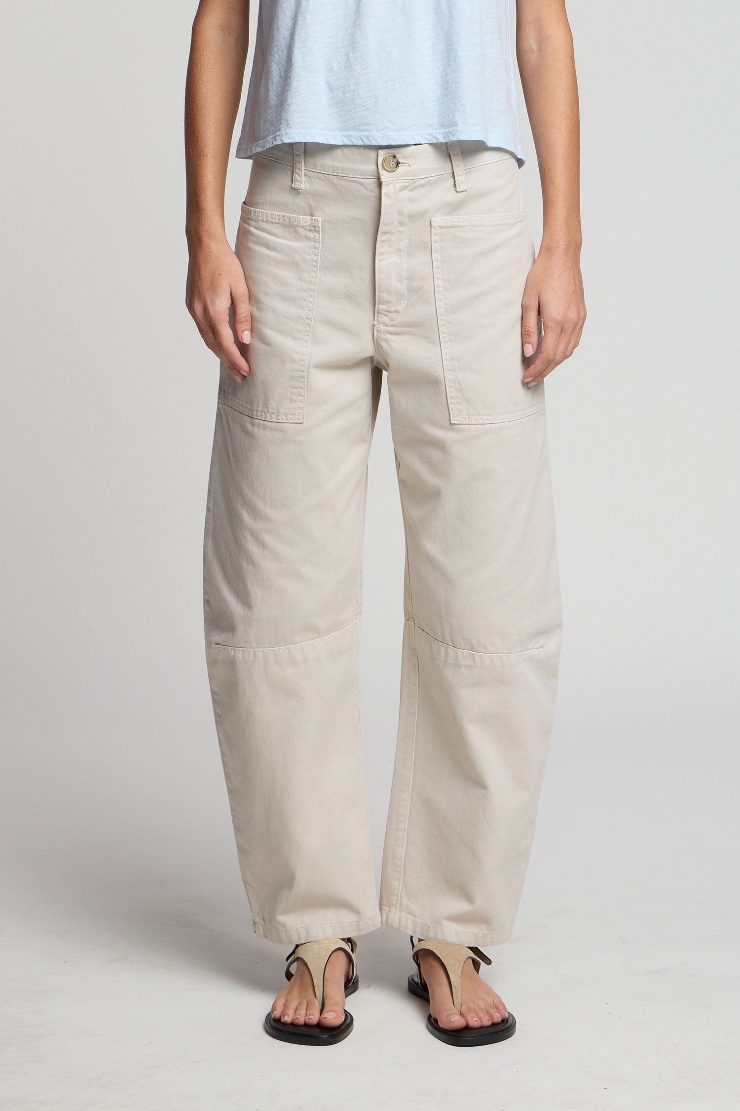 Person wearing beige pants on a plain background