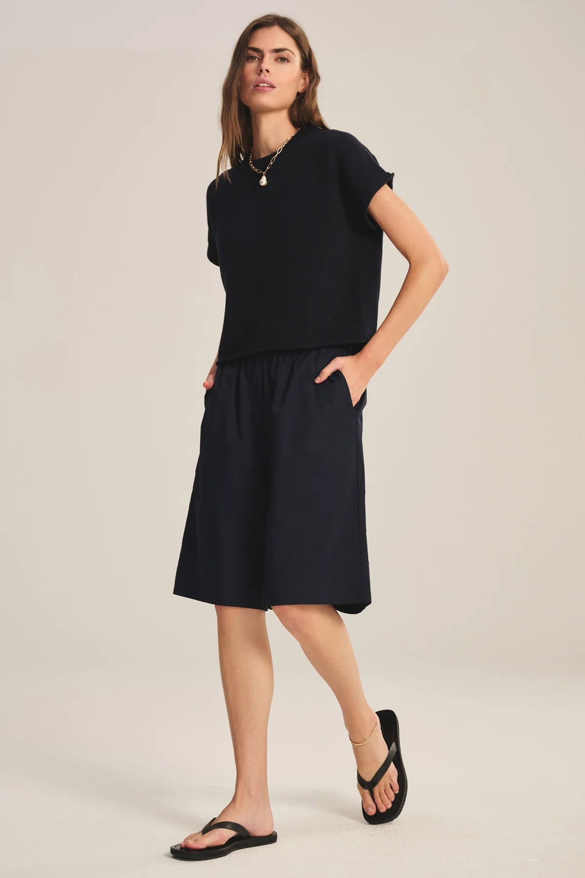 Woman wearing a black dress with a plain background