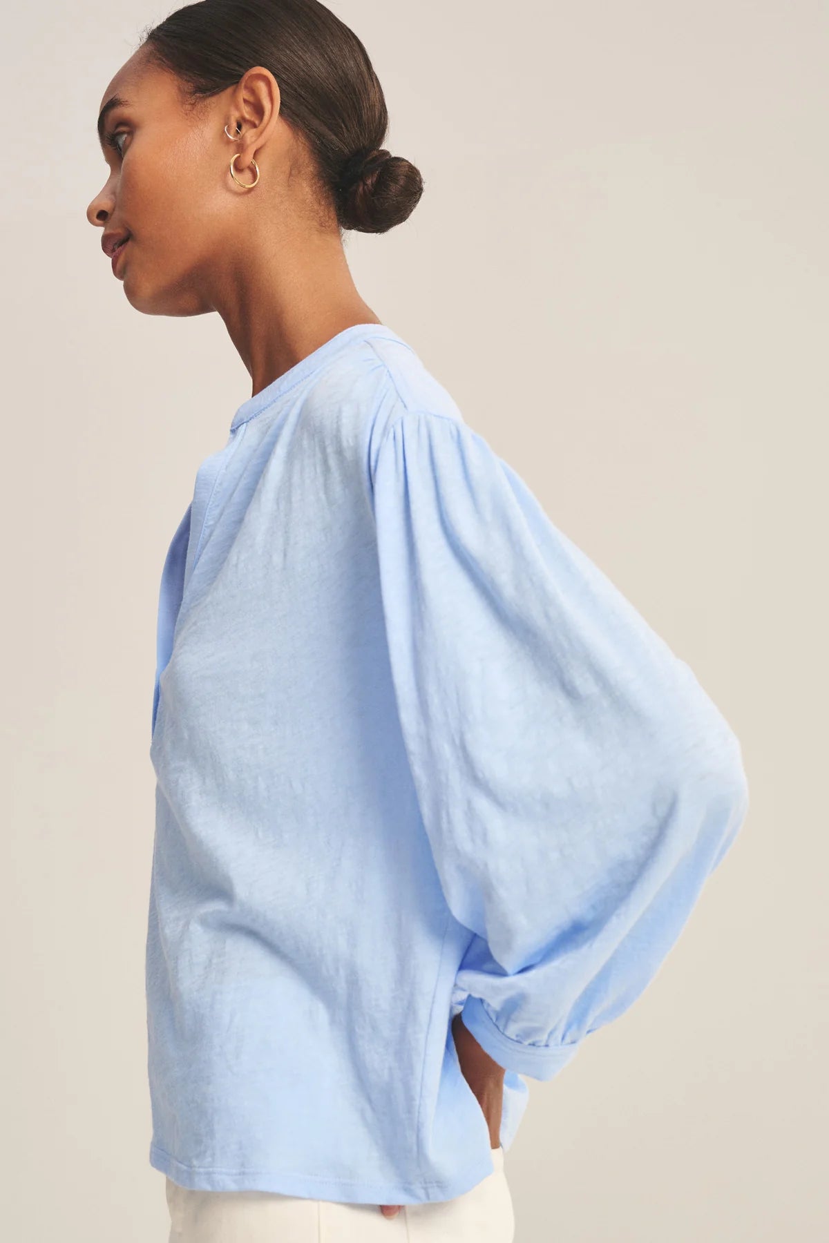 Woman wearing a light blue blouse against a beige background