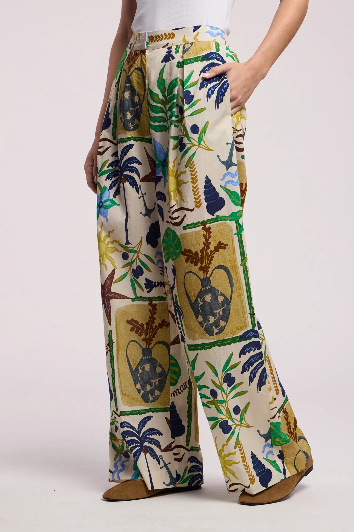 Tropical patterned pants worn by a person on a white background