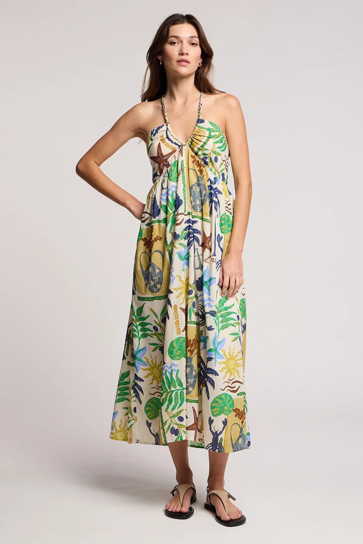 Woman wearing a colorful floral dress on a plain background