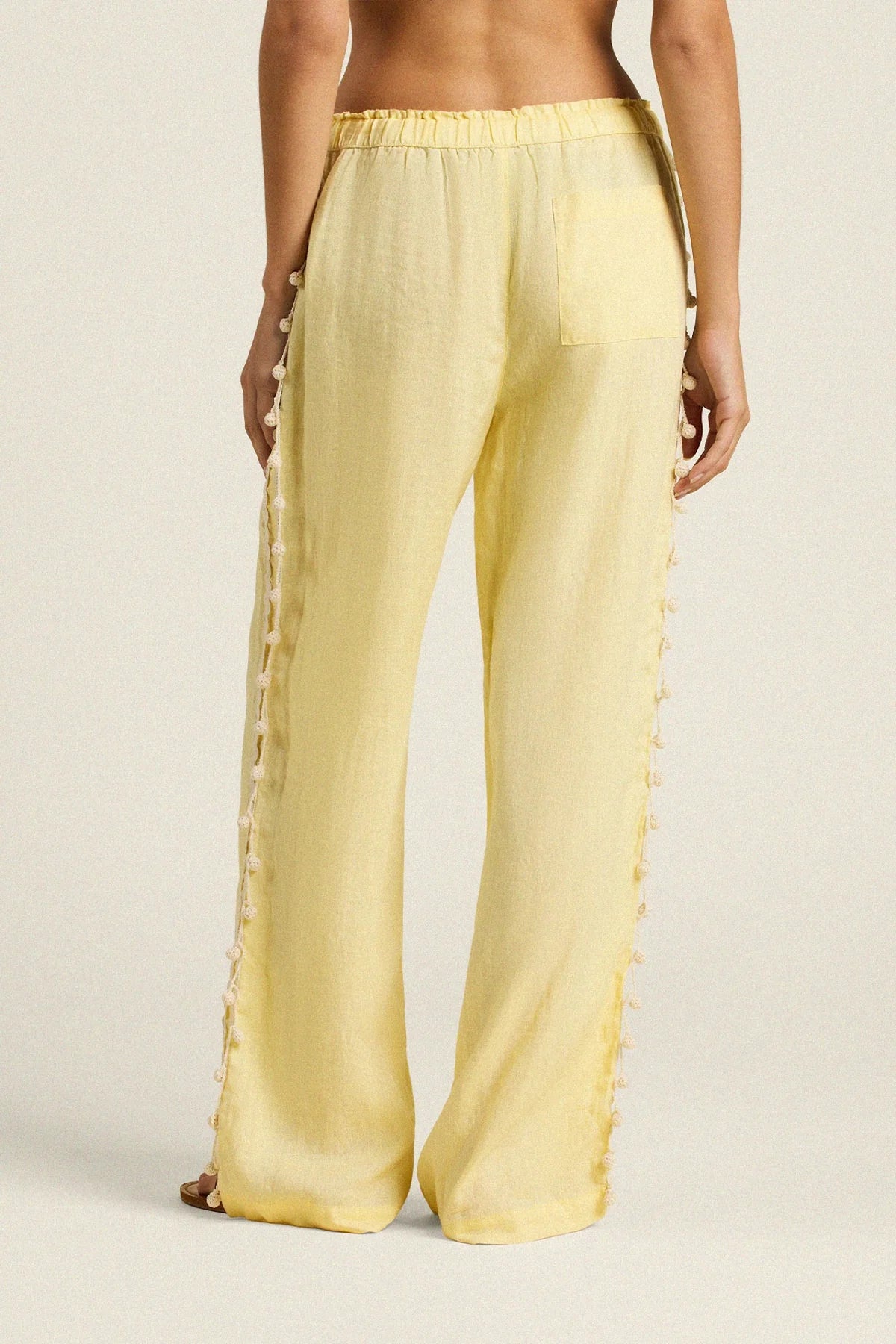 Yellow pants worn by a person on a beige background