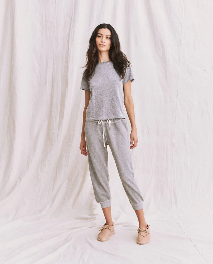 Woman wearing a gray pajama set against a white background