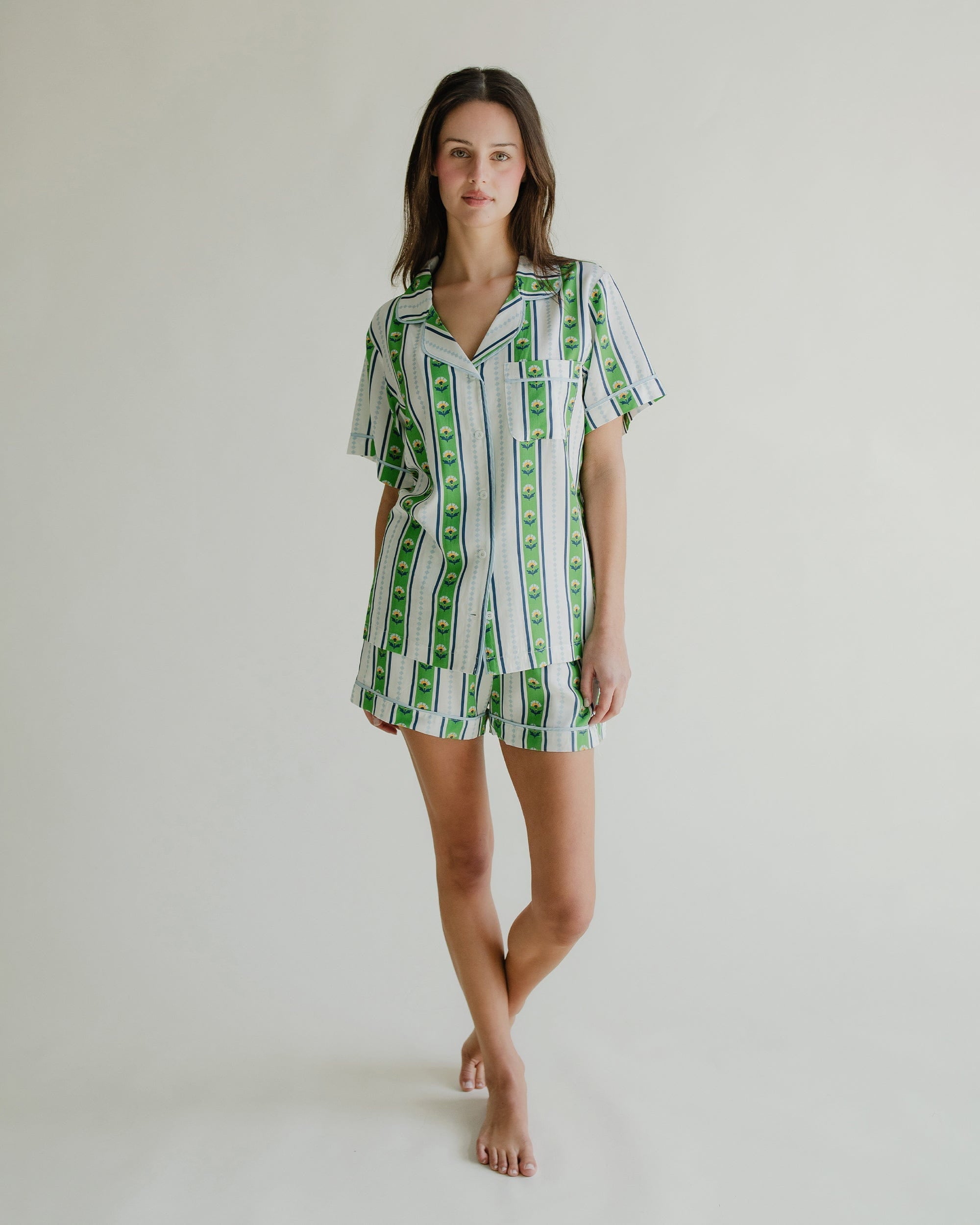 Woman wearing a green and white striped dress on a plain background