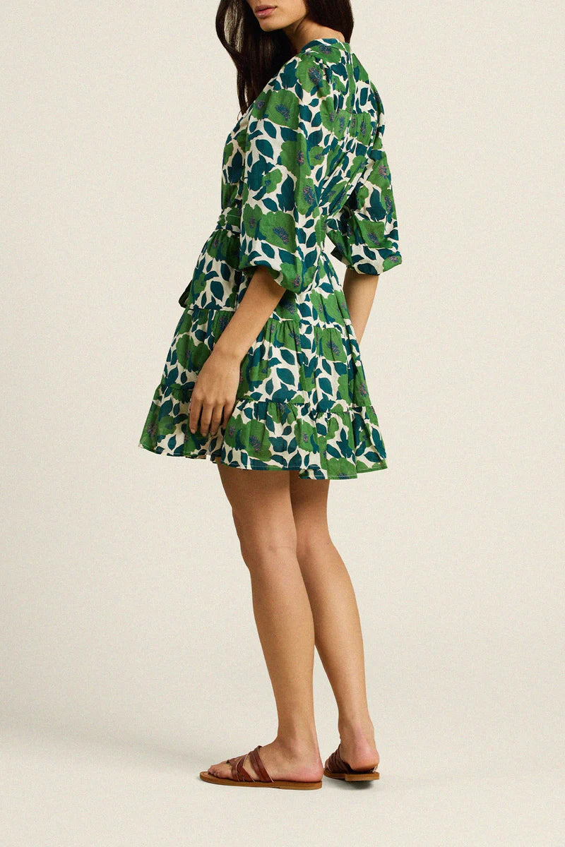 Woman wearing a green floral dress on a beige background