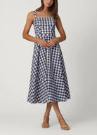 Woman wearing a blue and white checkered dress on a white background