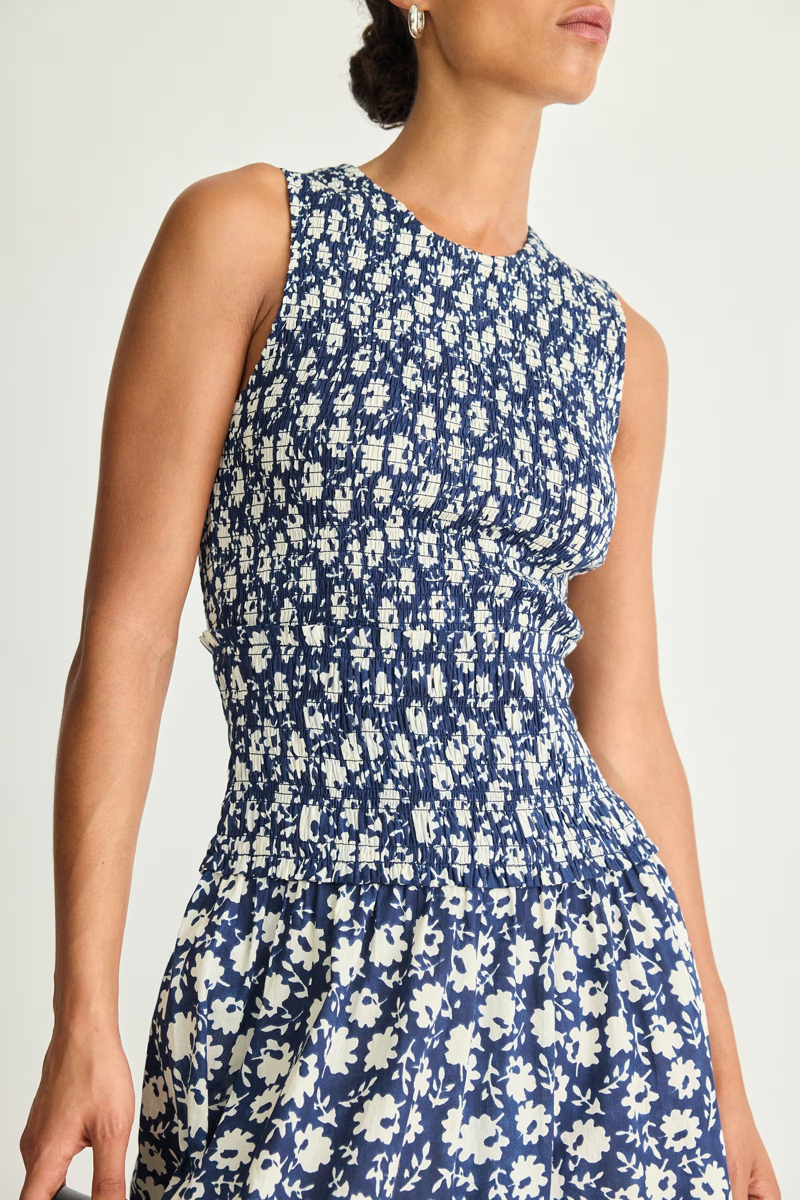 Woman wearing a blue floral dress against a white background