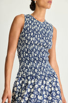 Woman wearing a blue floral dress against a white background