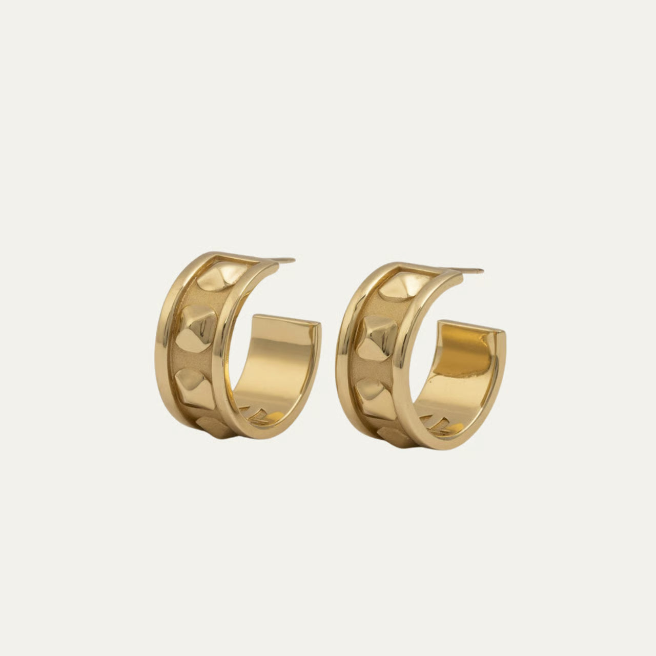 Pair of gold hoop earrings on a light beige background