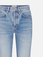 Close-up of light blue denim jeans on a white background