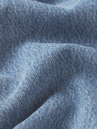 Close-up of blue denim fabric with a subtle pattern