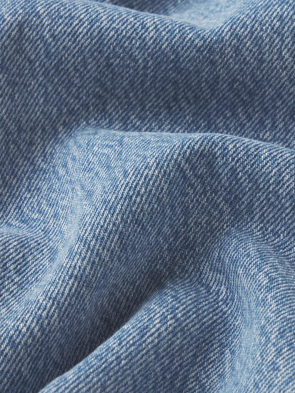 Close-up of blue denim fabric with a subtle pattern