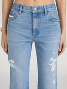 Light blue jeans with distressed details on a plain background