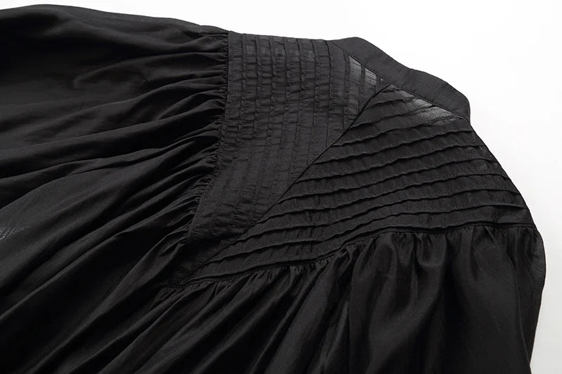 Close-up of a black skirt with pleated details on a white background