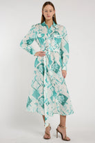 Woman wearing a long, patterned dress with a white background