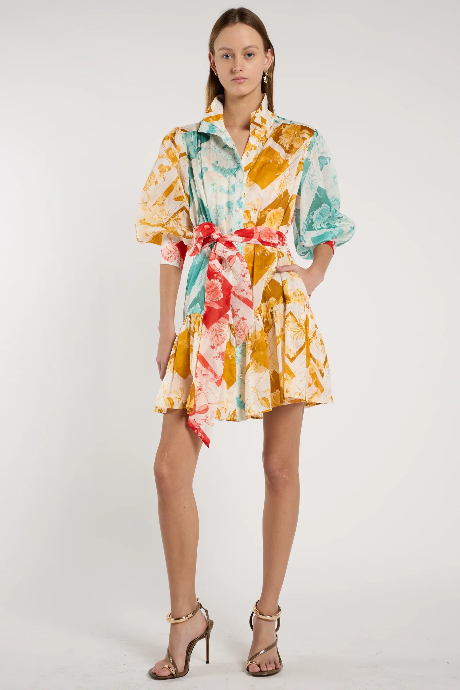 Model wearing a colorful floral dress on a white background